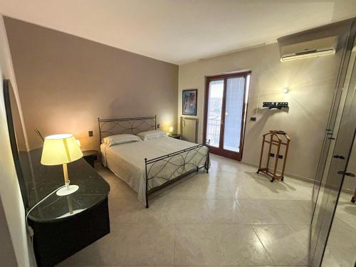 a bedroom with a bed and a table and a window at Dimora Il Roseto in Trani