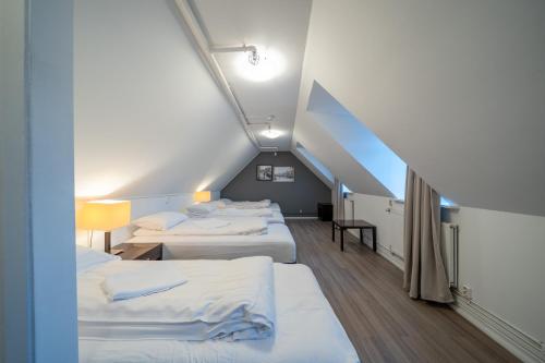 a room with three beds and a staircase at Old Town Reykjavik in Reykjavík