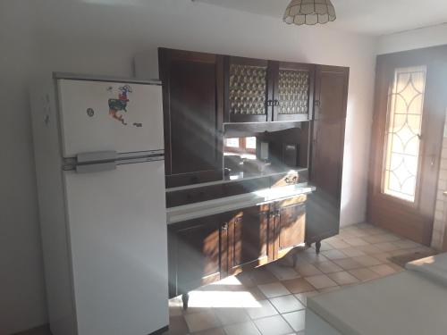 a kitchen with a stainless steel refrigerator and a window at Maison au tilleul in Ribiers