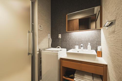 a bathroom with a sink and a washing machine at The LOFT INN NAGASAKI in Nagasaki