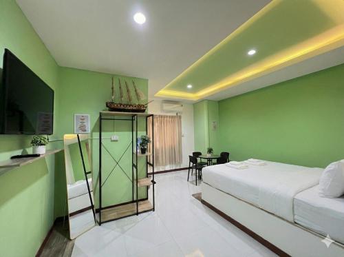 a bedroom with a bed and a television and a table at Similan Mondo Resort & Camping in Phangnga