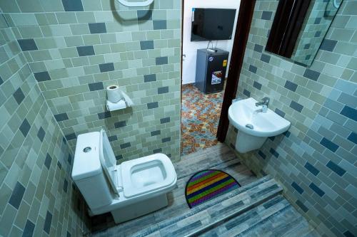 a bathroom with a toilet and a sink at Eastern Plus Hotel in Somanya