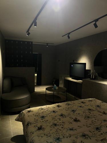 a bedroom with a bed and a chair and a television at استديو المنام الراقي in Medina