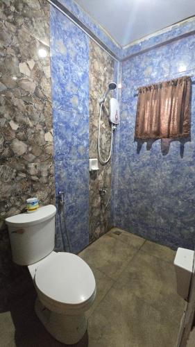 a bathroom with a toilet and a shower at D' TRAVELLERS Inn PUERTO in Puerto Princesa City