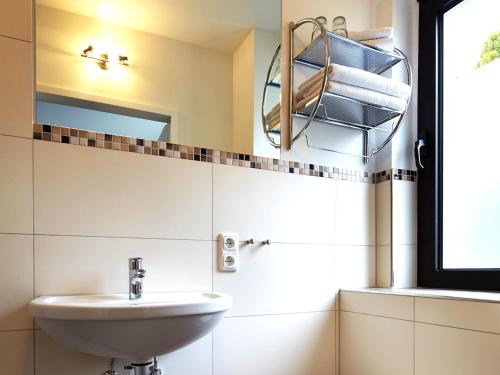 y baño con lavabo y espejo. en Hotel Hegemann garni en Hövelhof