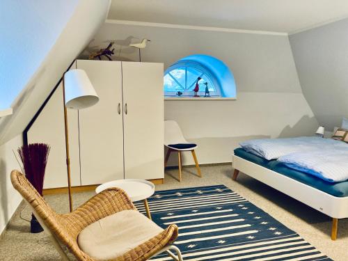a small bedroom with a bed and a chair at Achtern Diek 12b - Wohnung 5 in Müggenburg