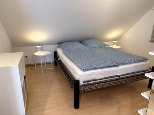 a bed in a room with two tables at Seewiefken 2 Dümmerblick in Lembruch