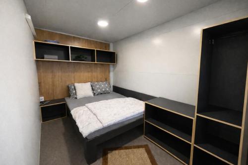 a small bedroom with a bed and shelves at Sea Mobile Home in Sukošan
