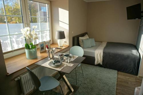 a bedroom with a bed and a table with chairs at Wohnung Burghaus 1 EG in Krummhörn