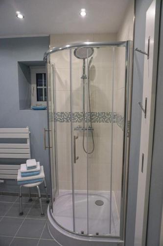 a shower stall in a bathroom with a chair at Wohnung Burghaus 1 EG in Krummhörn