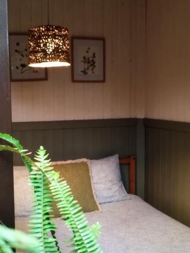 a bedroom with a bed and a chandelier at Natura Tiny House Porto in Valongo