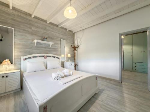 a bedroom with a white bed with towels on it at Stone Haven & Garden near the Sea in Methoni