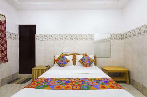 a bedroom with a large bed with colorful pillows at Via Neverland Residency in Pedappai