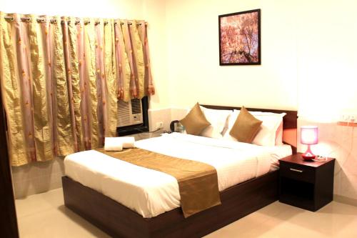 a bedroom with a bed and a window at Dragonfly Apartments Emerald in Mumbai