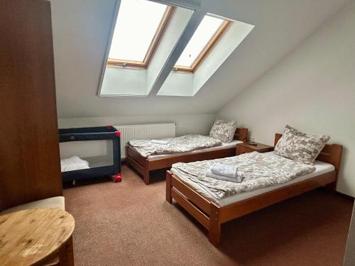 a attic room with two beds and a skylight at Noclegi Kołek in Pogórze