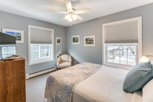 a bedroom with a bed and a tv and two windows at Shop, Dine, Unwind! Family Home in Dtwn Bar Harbor in Bar Harbor