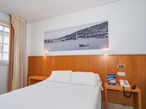a bedroom with a bed and a picture on the wall at Hotel del Mar Vigo in Vigo