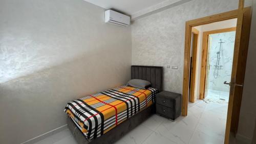 a small bedroom with a bed and a window at Selouane in Selouane