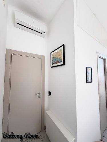 ein Badezimmer mit einer weißen Wand und einer weißen Tür in der Unterkunft La Muraria in Monterosso al Mare