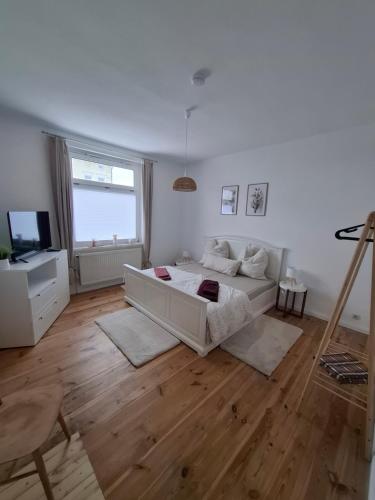 a white living room with a couch and a tv at Wohnung HoMe No 17 in Parchim