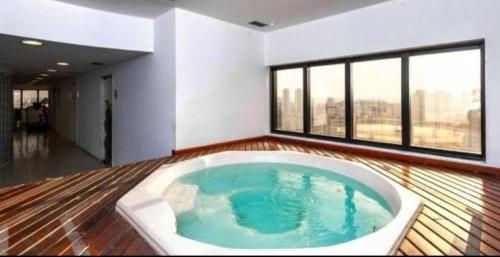 a large bath tub in a room with windows at GUARULHOS FLAT CENTER - Apart-Hotel in Guarulhos