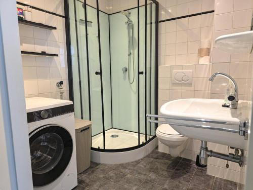 a bathroom with a shower toilet and a washing machine at Vakantie appartement Chava WE09 in Westkapelle