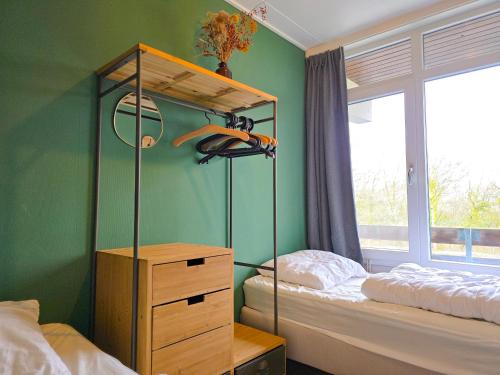 a bedroom with a bed and a dresser next to a window at Vakantie appartement Chava WE09 in Westkapelle