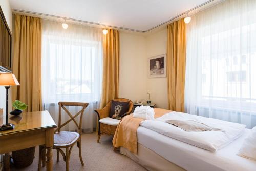 a hotel room with a bed and a desk at Hotel zur Mühle in Paderborn