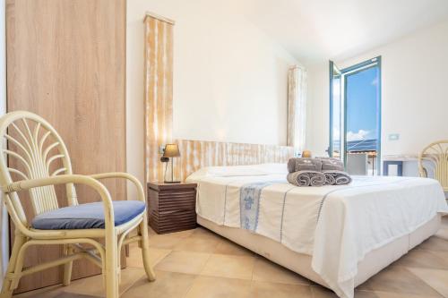 a bedroom with a bed and a chair and a window at Hotel Montiruju in Santa Maria