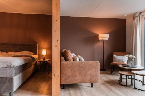 a hotel room with a bed and a chair at Appartement Wadpier in Buren