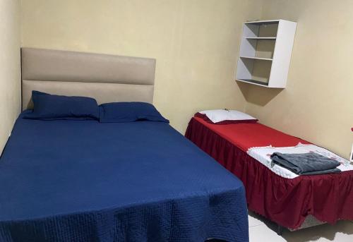 a bedroom with two beds with blue and red sheets at Ramos hotel in Barreirinhas