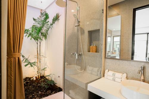a bathroom with a shower and a sink at Dkenyeri Villa by Aayan in Tanah Lot