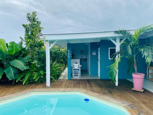 a house with a swimming pool and a blue house at Papaye et coconut in Anse-Bertrand