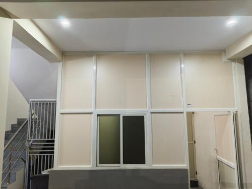 a large white wall in a building with a staircase at Rr suites in Kākināda