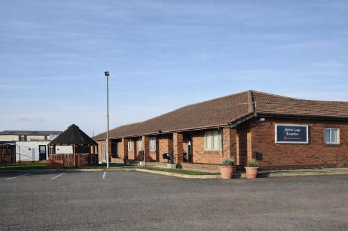 a brick building with a parking lot in front of it at The Mayfair Lodge & Family Suite in Hartlepool