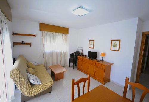 a living room with a couch and a desk at Villamar Orange Costa in Benicàssim