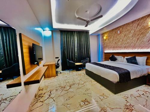 a hotel room with a bed and a flat screen tv at The Grand Oasis Hotel & Resort I Near India Expo Mart in Greater Noida