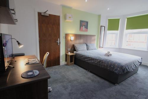 a bedroom with a bed and a desk and a desk at Victoria House - Deluxe Studios in Coventry City Centre, free parking, by COVSTAYS in Coventry