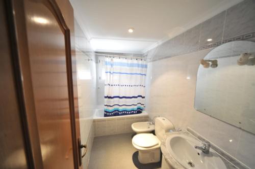 a bathroom with a toilet and a sink and a mirror at Villamar Orange Costa in Benicàssim