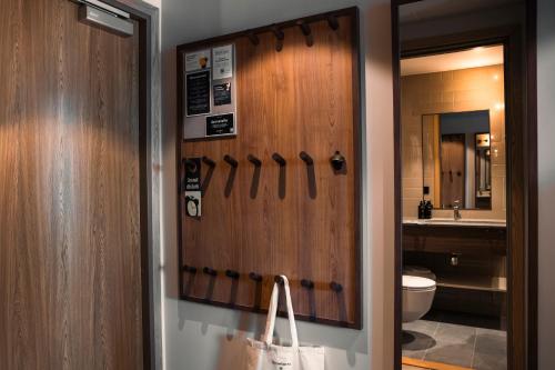 ein Badezimmer mit einer Holztür und einer Handtasche in der Unterkunft Quality Hotel The Book in Göteborg