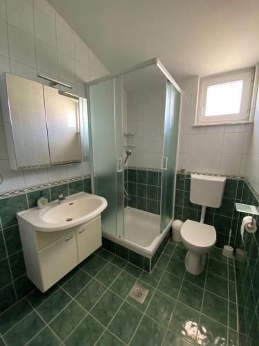 a bathroom with a sink and a toilet and a shower at Apartman Palma in Vir