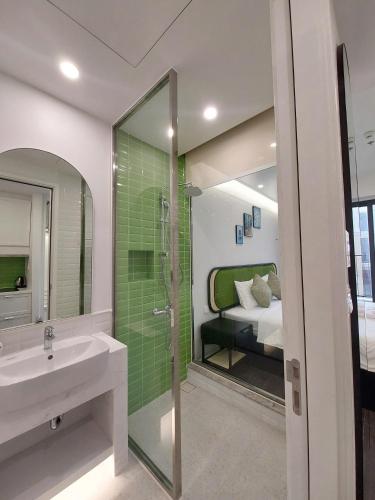 a bathroom with a sink and a shower and a bed at Sunset town Phú Quốc in Phú Quốc
