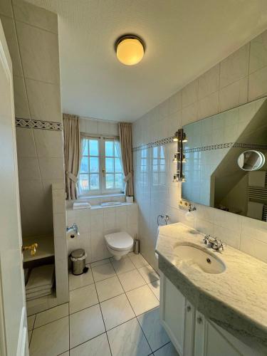 a white bathroom with a sink and a toilet at Landhaus-Duenenhof in Rantum