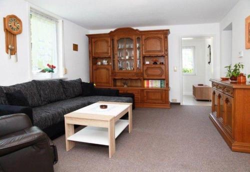 a living room with a black couch and a coffee table at Ferienwohnung-Hoffmann-Harzgerode in Harzgerode