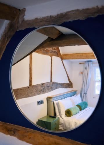 a bedroom with a bed and a round mirror at City Rooms by Hiive in Worcester