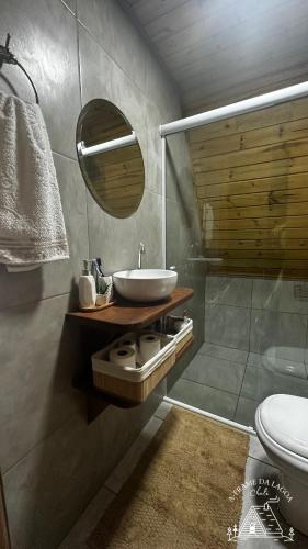 a bathroom with a sink and a toilet and a mirror at A-Frame da Lagoa in Imaruí