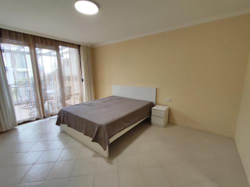 a bedroom with a bed and a large window at Santa Marina Breeze - One bedroom apartment in Sozopol