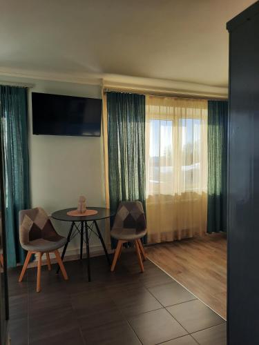 un soggiorno con tavolo e sedie e una finestra di Studio Apartment 2 a Rēzekne