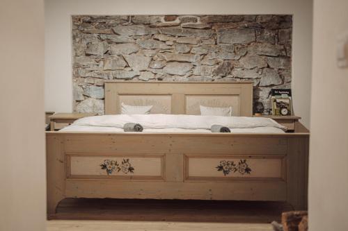 a bed in a room with a stone wall at Chaloupka Kunčice in Staré Město