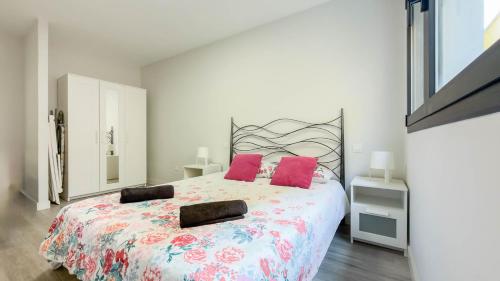 a bedroom with a large bed with pink pillows at Guanarteme Vista Surf, Las Canteras in Las Palmas de Gran Canaria